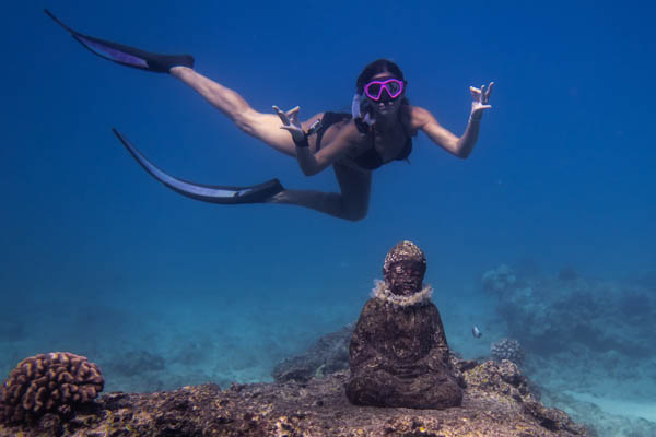 Taucherin mit Statue, mit der passenden Reiseversicherung zum Unterwassermuseum