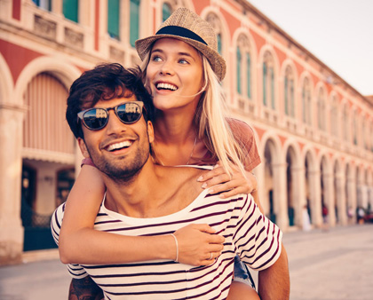 Frau mit Hut, Mann mit Sonnenbrille auf einer Urlaubsreise