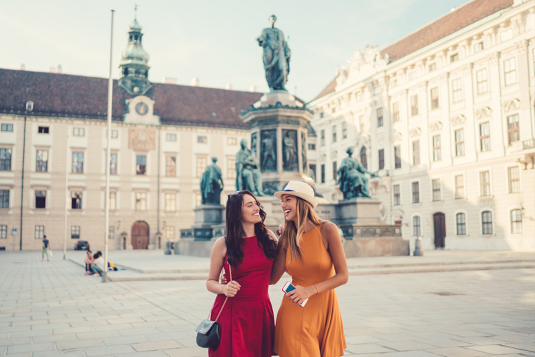 Zwei lachende Frauen auf Städtereise