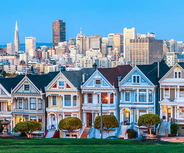 Painted Ladies in San Francisco mit Skyline und Transamerica Pyramid im Hintergrund