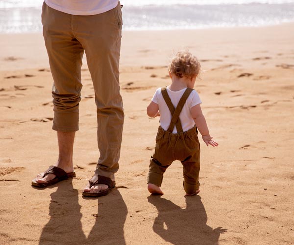 Baby mit Vater am Strand