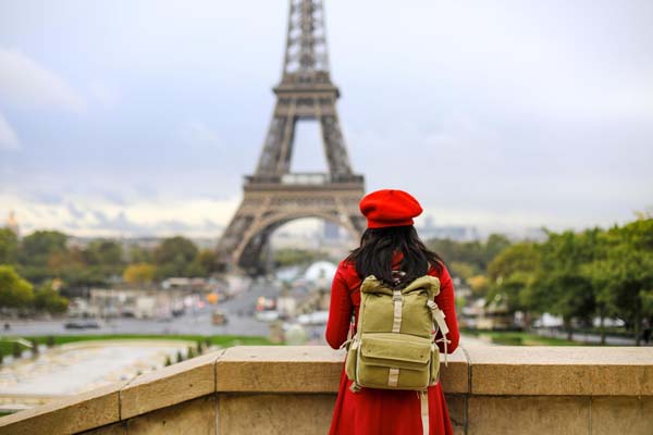 Mit leichtem Gepäck reisen - Touristin mit Rucksack in Paris