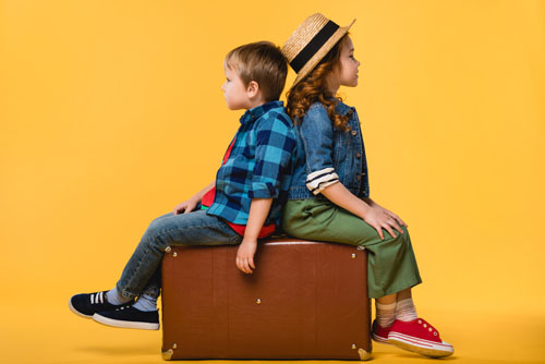 Kinder sitzen auf einem Koffer