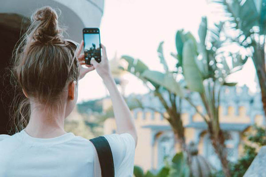Frau mit Handy im low budget Urlaub