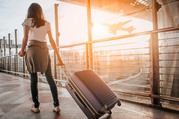 Frau zieht Koffer am Flughafen