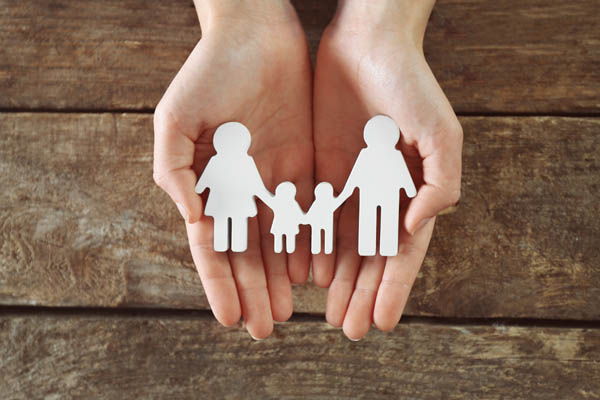 Hände die eine Familie beschützen