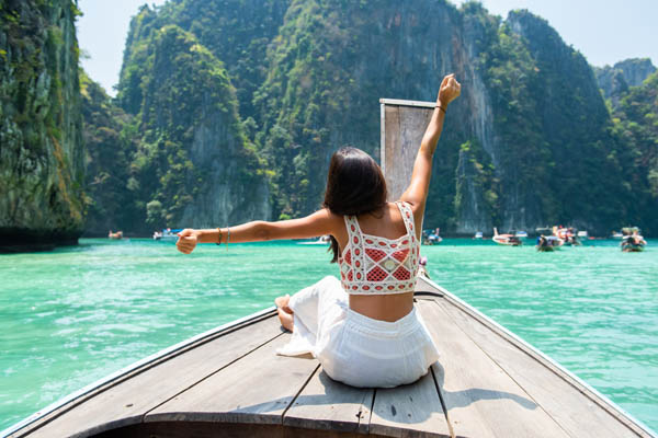 Frau streckt sich entspannt auf einem Boot in Thailand
