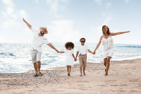 Familie mit zwei Kindern spaziert am Strand