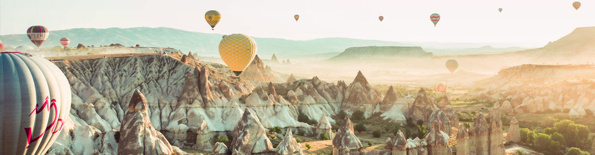 Bergige Landschaft in der Türkei mit vielen bunten Heißluft-Ballons