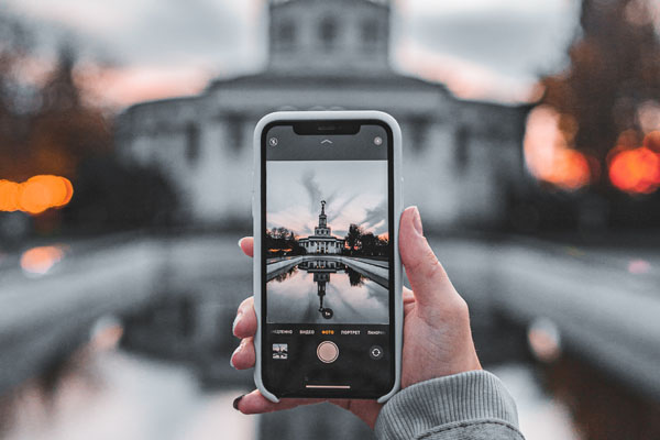 Hand mit Smartphone fotografiert Sehenswürdigkeit