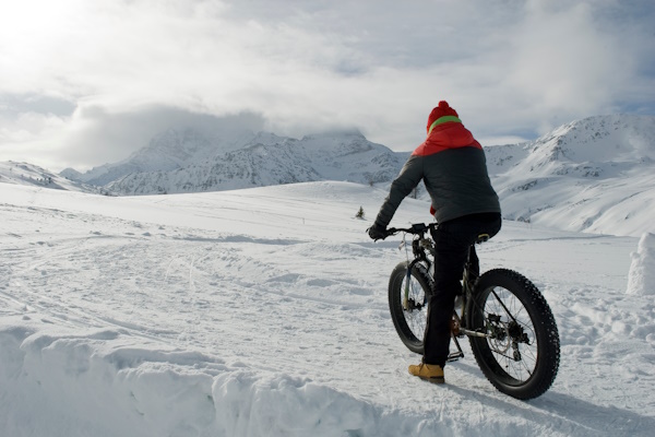 Mann fährt mit einem Fatbike durch den Schnee