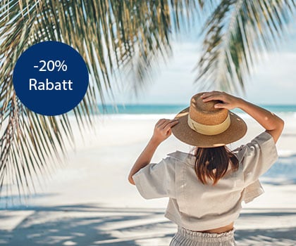 Frau mit Sonnenhut genießt einen schönen Sommertag am Palmenstrand