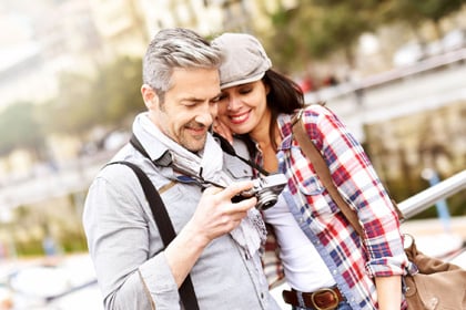 Lächelndes Paar auf Urlaub mit Digitalkamera