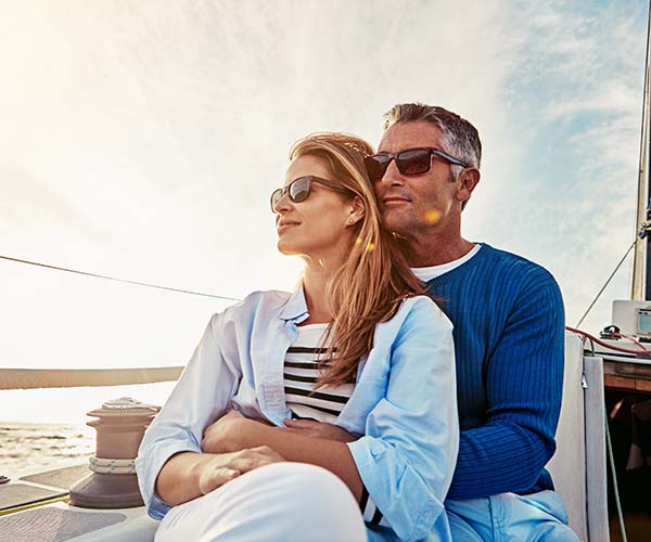 Mann und Frau mit Sonnenbrille auf einem Boot