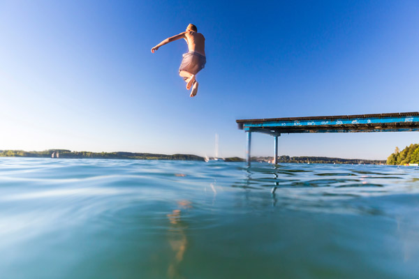 Junge sprint ins Wasser aus einem Steg am Bodensee