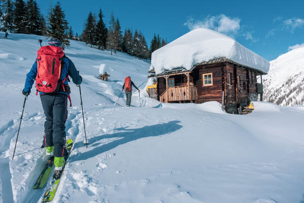 Schneepiste mit Hütte um Skilangläufer