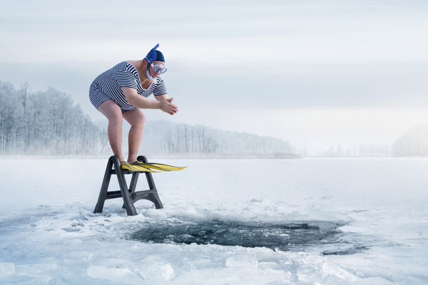 Ein Mann mit Schnorchelausrüstung springt ins Eiswasser
